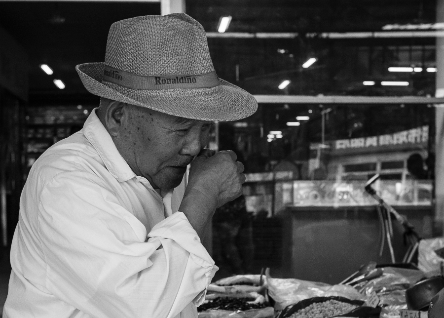 Peking; an old man at the market