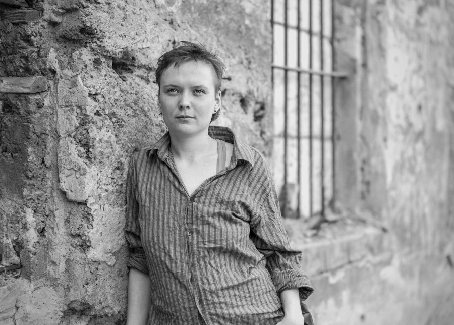 girl with a striped shirt leaning against the wall