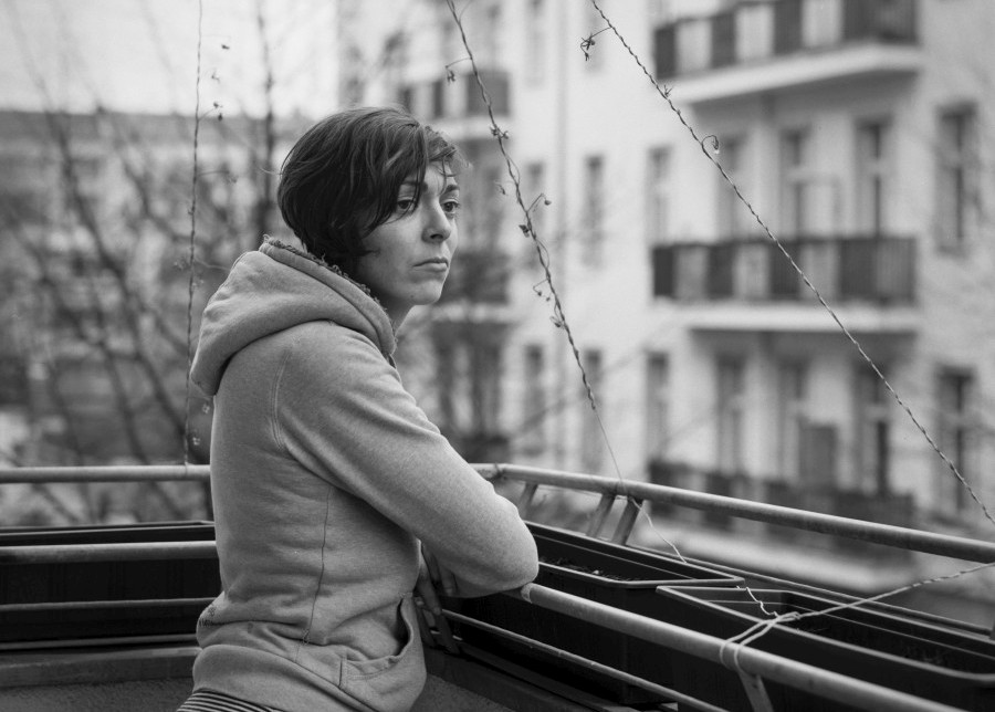 a woman on a balcony looks in the distance